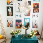 A woman arranging flowers in a modern art gallery setting with vibrant wall paintings.