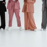 Fashionable women in stylish suits posing indoors on a white background.