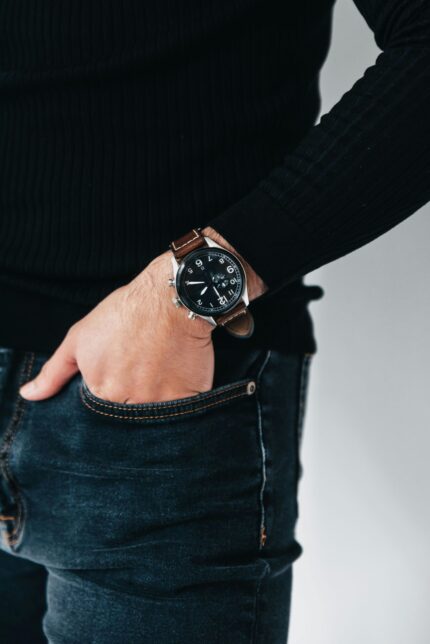 Close-up shot of a person wearing a stylish leather wristwatch with hand in pocket.