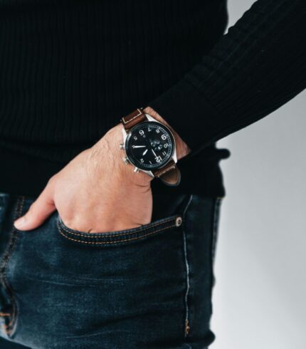 Close-up shot of a person wearing a stylish leather wristwatch with hand in pocket.