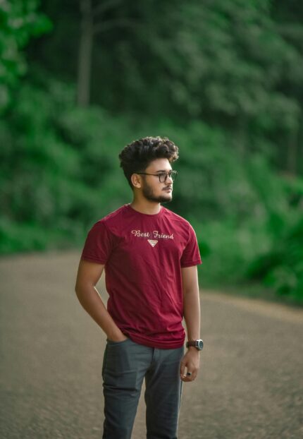 Casual young man gazing into the distance on a forest path.